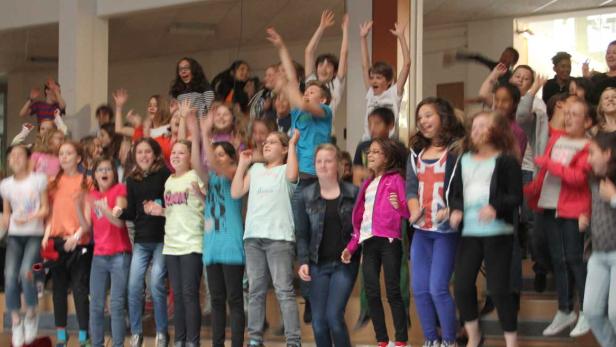 Eine Gruppe von Kindern springt und jubelt auf einer Treppe.