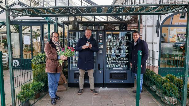 Drei Männer stehen vor einem Automaten der Firma Doellerer.