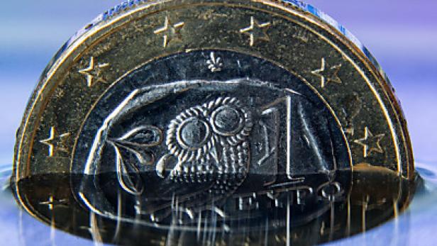 Eine griechische 1-Euro-Münze liegt im Wasser.