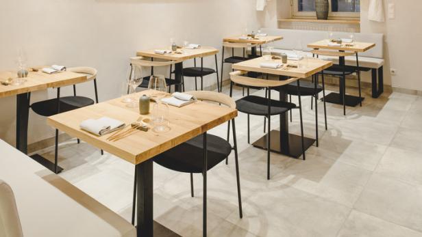 Ein modern eingerichtetes Restaurant mit Tischen und auffälliger Beleuchtung.