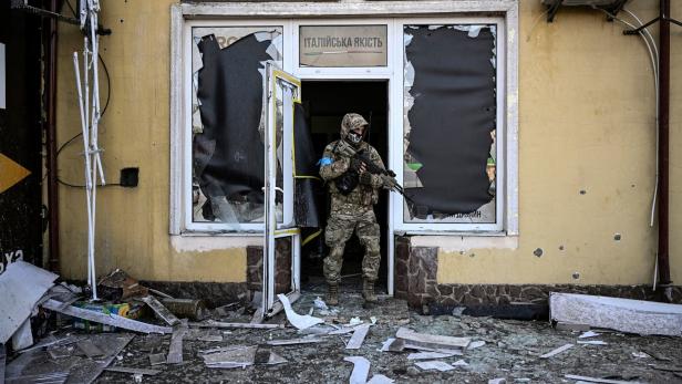Ukrainischer Soldat vor zerstörtem Gebäude in Mariupol
