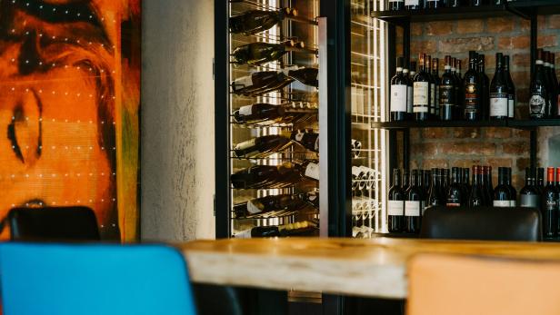 Ein Weinregal und ein Weinkühlschrank in einem Restaurant.