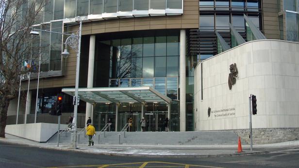 Das Criminal Courts of Justice Gebäude in Dublin mit Passanten vor dem Eingang.