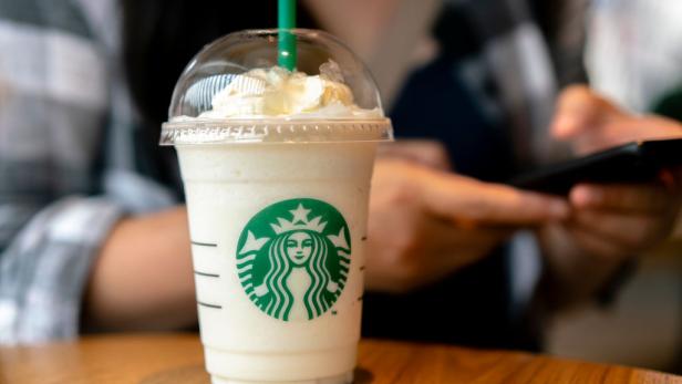 Ein Starbucks-Frappuccino mit Sahne auf einem Holztisch.