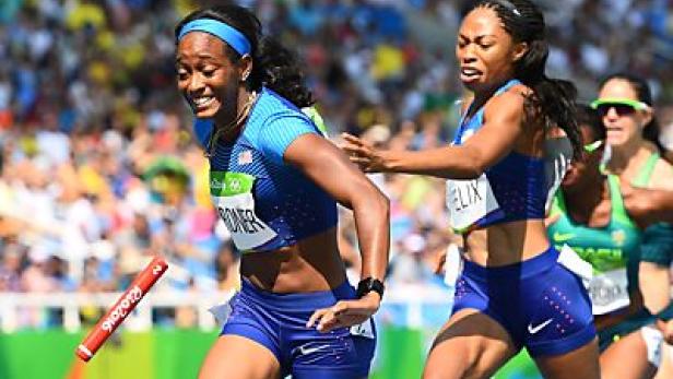 Zwei US-amerikanische Sprinterinnen wechseln bei einem Staffellauf den Staffelstab.