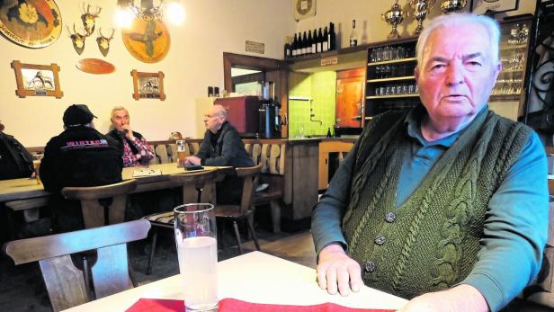 Ein älterer Mann sitzt an einem Tisch in einem traditionellen Lokal.