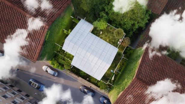 Ein Stadtbaumhaus mit weißem Dach, umgeben von Gärten und Bäumen, von oben gesehen.