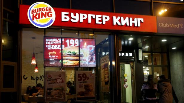 FILE PHOTO: FILE PHOTO: Women walk outside a Burger King restaurant in Moscow