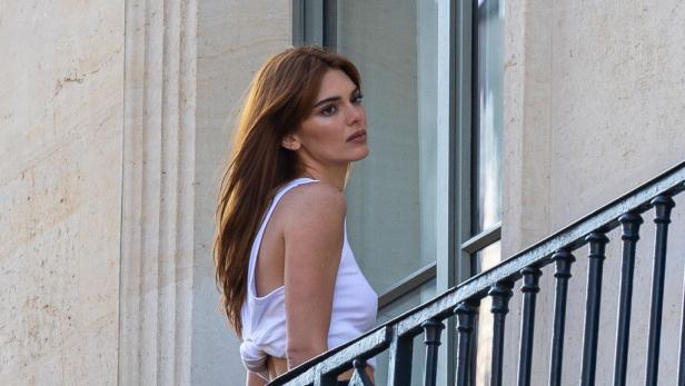 Kendall Jenner steht auf einem Balkon und blickt zur Seite.