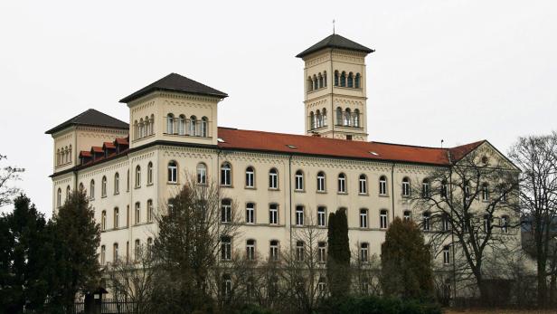 Ein großes, helles Gebäude mit einem Turm und vielen Fenstern.