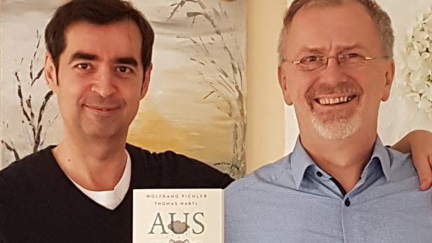 Zwei Männer posieren mit dem Buch „Aus die Maus“ von Wolfgang Pichler und Thomas Hartl.