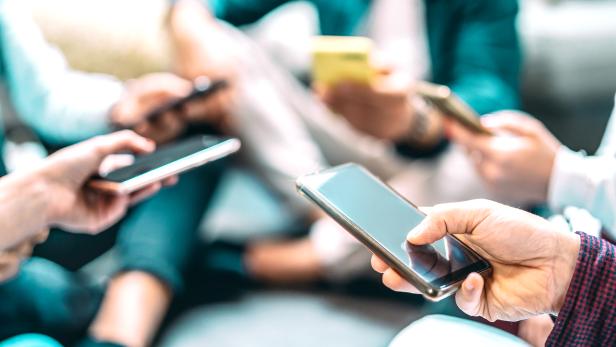 Close up of people using mobile smart phones - Detail of friends sharing photos on social media network with smartphone - Technology concept and cellphone culture with selective focus on right hand