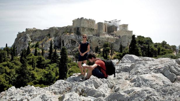 Zwei Touristen vor der Akropolis in Athen.