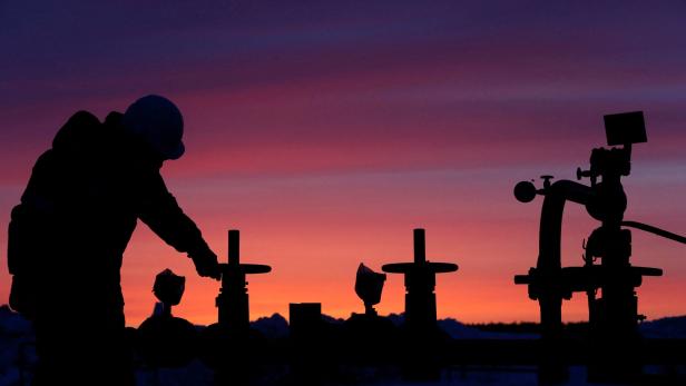 FILE PHOTO: Worker checks valve of oil pipe at oil field owned by Bashneft company near Nikolo-Berezovka