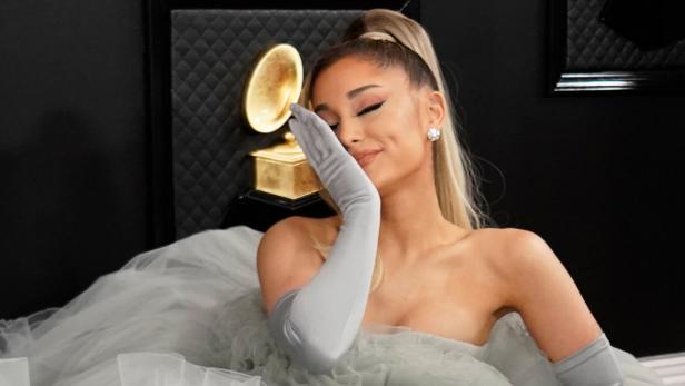Ariana Grande posiert mit einer Grammy-Trophäe.
