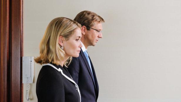 Eine Frau in einer schwarzen Jacke und ein Mann mit Brille im Profil.