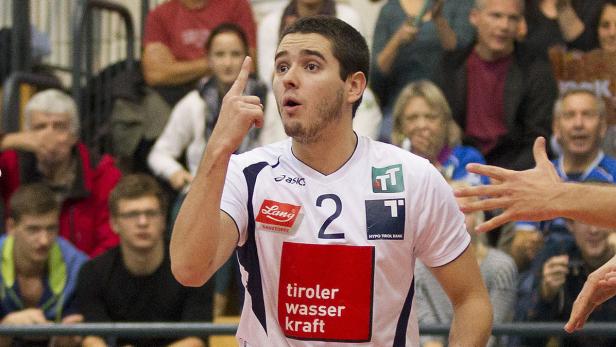 Ein Volleyballspieler zeigt mit dem Finger nach oben, im Hintergrund Zuschauer.