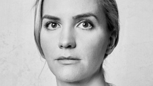 Schwarzweiß-Porträt einer Frau mit hellen Haaren und ernstem Blick.