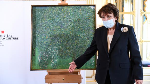 French Culture Minister Roselyne Bachelot poses next to the painting "Rosebushes under the Trees" by Austrian painter Gustav Klimt in Paris