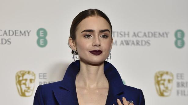 Lilly Collins mit Schuhproblemen bei "Emily in Paris"