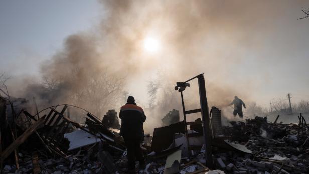 Residents extinguish a fire after a bombing destroyed a family home in a northern district of Kharkiv as Russia's attack on Ukraine continues
