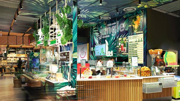 Ein Edeka-Center im Weserpark mit tropischer Dekoration und einer Saftbar.