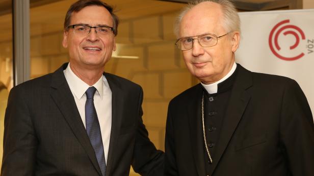 Zwei Männer in Anzügen posieren für ein Foto.
