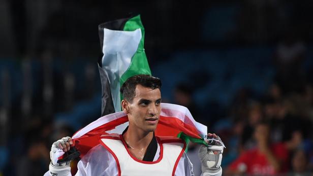 Ein Taekwondo-Sportler trägt die palästinensische Flagge.