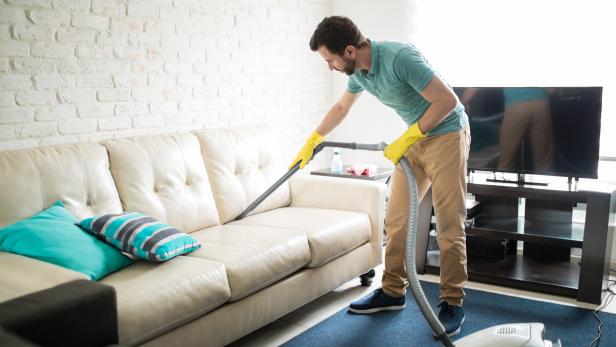 Latin man cleaning the sofa