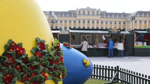 Gelbe und blaue Ostereier mit Blumen vor dem Schloss Schönbrunn.