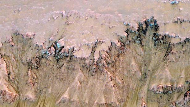 Im Fachjournal Nature Geoscience berichten die Wissenschaftler, dass sie auffällige Fließstrukturen untersucht haben, die sich im Sommer regelmäßig an manchen Steilhängen auf dem Mars formen.