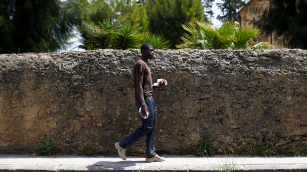 Ebrima Sanneh, 17, from Gambia walks to an immigration centre in the Sicilian town of Caltagirone, Italy April 22, 2016. Sanneh arrived in Italy this year by boat from Libya. &quot;They rob you and take your money, or if they see you have no money on you, they kill you,&quot; he said. REUTERS/Tony Gentile SEARCH &quot;TONI CHILD&quot; FOR THIS STORY. SEARCH &quot;THE WIDER IMAGE&quot; FOR ALL STORIES