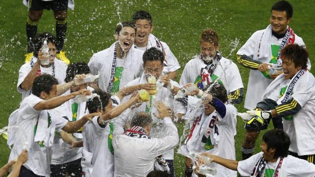 Japan&#039;s soccer players splash drinks on their coach Alberto Zaccheroni (C) as they celebrate becoming the first side to qualify for the World Cup finals in Brazil after their 2014 World Cup qualifying soccer match against Australia in Saitama, north of Tokyo, June 4, 2013. Asian champions Japan became the first side to qualify for the World Cup finals in Brazil when playmaker Keisuke Honda scored an injury time penalty to claim a 1-1 draw with Australia in Saitama on Tuesday. REUTERS/Toru Hanai (JAPAN - Tags: SPORT SOCCER)
