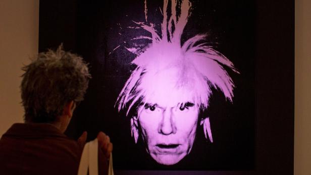 FILE PHOTO: A man examines "Self-Portrait" by Andy Warhol during a media preview at Christie's auction house in New York