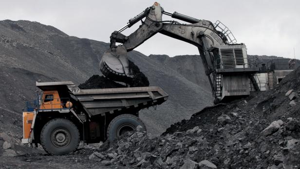 FILE PHOTO: A machine loads dump-body truck with coal at Chernigovsky opencast colliery in Kemerovo region, Siberia, Russia