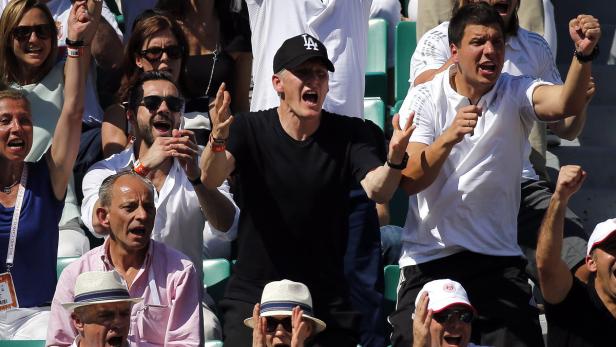Eine Menschenmenge, darunter Bastian Schweinsteiger, feuert bei einer Sportveranstaltung an.