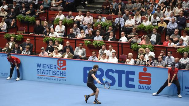 Ein Tennisspieler beim Aufschlag während eines Matches vor Publikum.