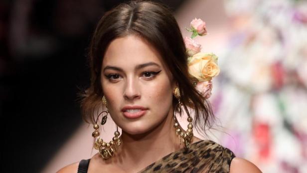 Ashley Graham trägt ein Leopardenkleid und Blumen im Haar auf dem Laufsteg.