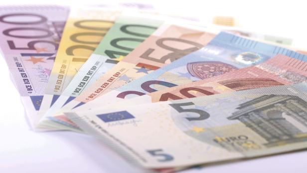 Verschiedene Euro-Banknoten liegen fächerförmig auf einem Tisch.