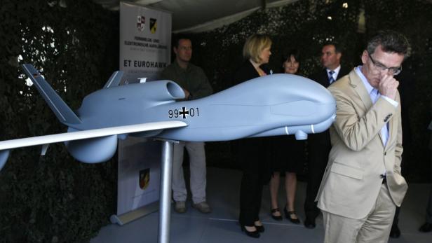 File picture shows German Defence Minister Thomas de Maiziere as he stands next to a model of the Euro Hawk unmanned aerial vehicle (UAV) during his visit to the Joint Support Service base in Grafschaft near the western German city of Bonn July 12, 2011. Germany will not purchase Euro Hawk reconnaissance drones because meeting the standards required to win aviation approval would cost 500 million to 600 million euros, a German government source told Reuters on May 14, 2013. German armed forces have one prototype Euro Hawk and were considering whether to purchase an additional four drones, which are made by EADS and Northrop Grumman. Picture taken July 12, 2011. REUTERS/Wolfgang Rattay/Files (GERMANY - Tags: POLITICS MILITARY BUSINESS)
