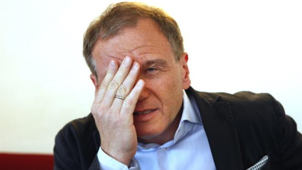 Ein Mann hält seine Hand vor das Gesicht.
