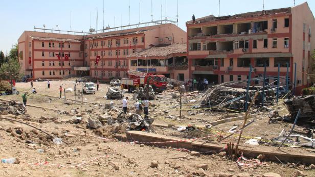 Nach einer Explosion zeigt das Bild ein beschädigtes Gebäude und Trümmer auf dem Boden.