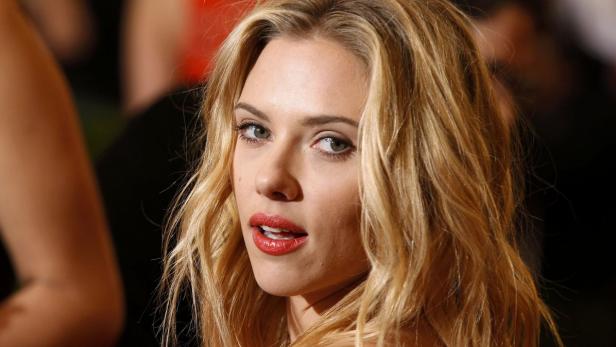 Ein Porträt von Scarlett Johansson mit blonden, gewellten Haaren und rotem Lippenstift.