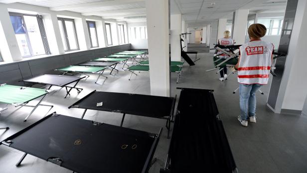 Ein Raum mit Feldbetten, in dem Helfer des Team Österreich arbeiten.