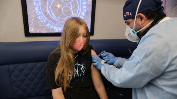 Parsia Jahandani gives Savannah, 12, hepatitis, HPV, and meningitis vaccines at a back-to-school coronavirus disease (COVID-19) and other vaccination clinic, in Westminster