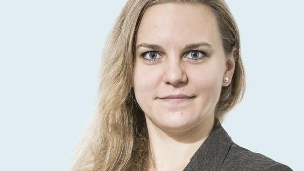 Porträt einer Frau mit blonden Haaren und einem grauen Blazer.