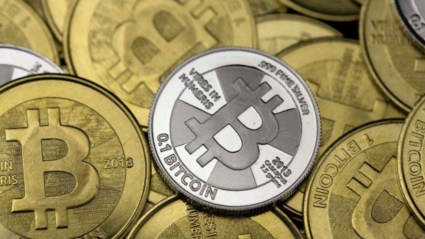 Mehrere goldene und silberne Bitcoin-Münzen liegen übereinander.