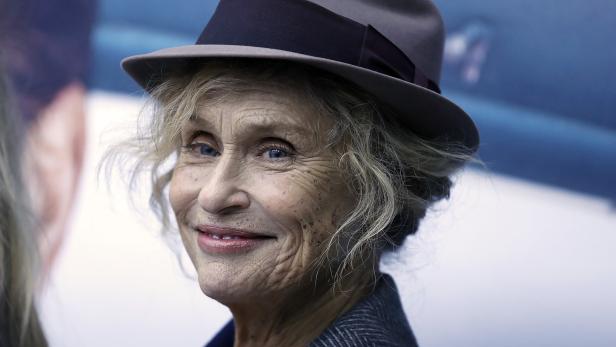 Nahaufnahme von Faye Dunaway mit Hut und grauem Blazer.