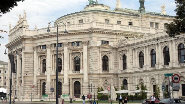 Die Wiener Staatsoper, ein prachtvolles Gebäude mit Statuen und architektonischen Details, an einem belebten Platz.