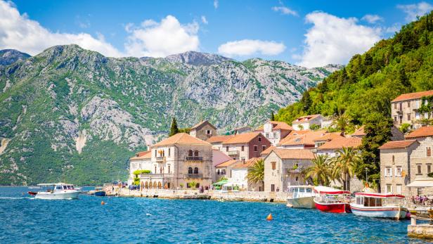 Blick auf die Küstenstadt Perast in Montenegro mit Bergen im Hintergrund.